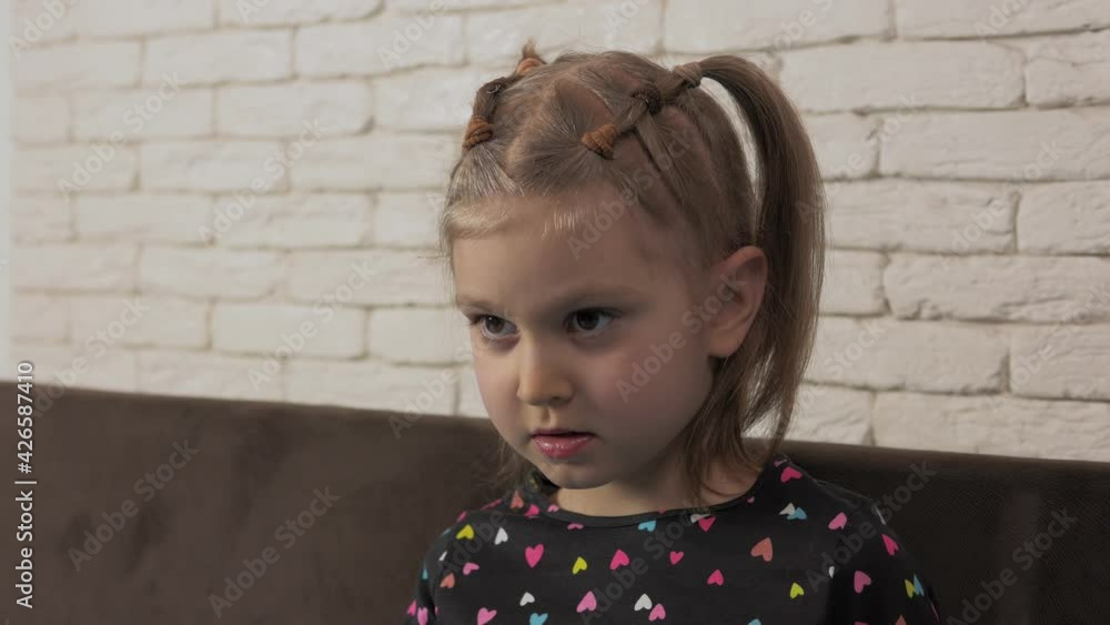 Close-up portrait of a little girl, carefully looking at the TV screen or the interlocutor. Close-up portrait of a little girl, carefully looking at the TV screen or the interlocutor.