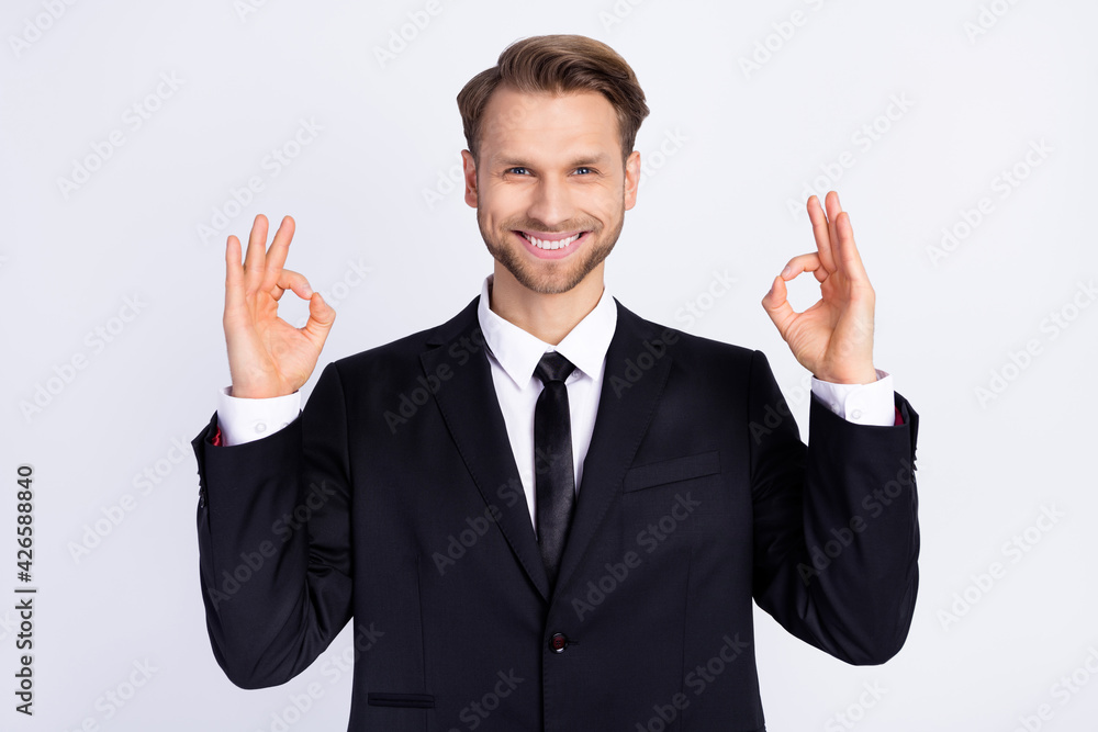 Photo of young man happy positive smile show okey alright perfect done sign isolated over grey color background Photo of young man happy positive smile show okey alright perfect done sign isolated over grey color background