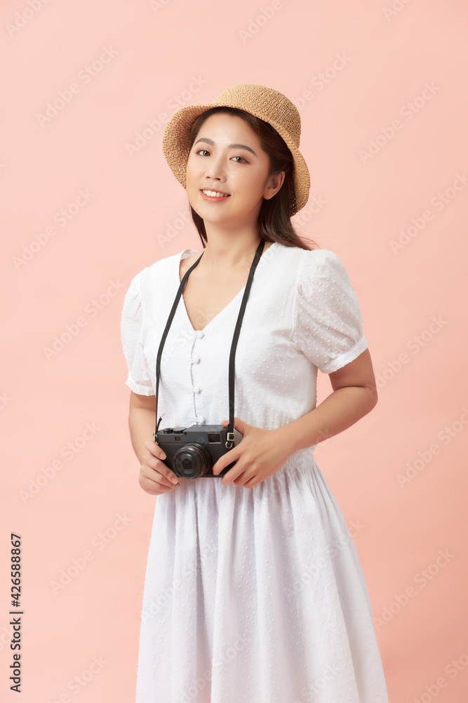 Young beautiful teen female in straw hat holding camera smiling happy, over pink background Young beautiful teen female in straw hat holding camera smiling happy, over pink background