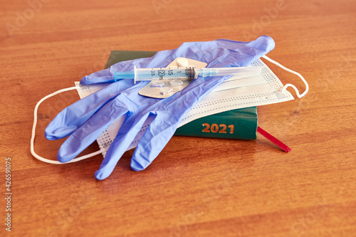 The concept of coronavirus in 2021. Business notebook of 2021 with a glove mask and medicines