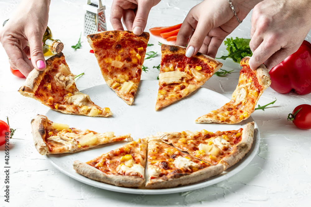 Traditional Italian pizza, vegetables, ingredients. Pizza is cooking in the oven. People Hands Taking Slices Of Pizza. Pizza menu on a light background, top view