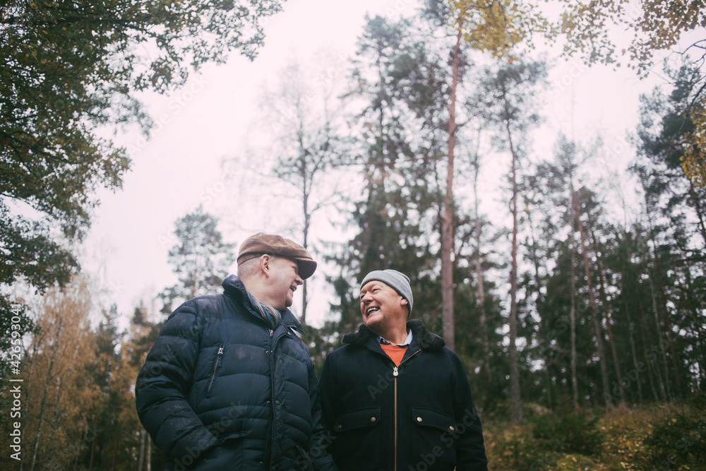Cheerful gay couple talking with each other in forest Cheerful gay couple talking with each other in forest
