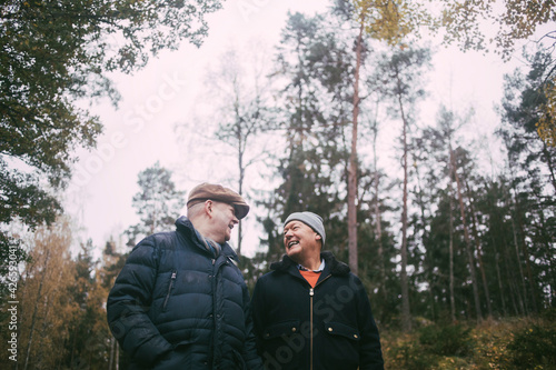 Wallpaper Mural Cheerful gay couple talking with each other in forest Torontodigital.ca