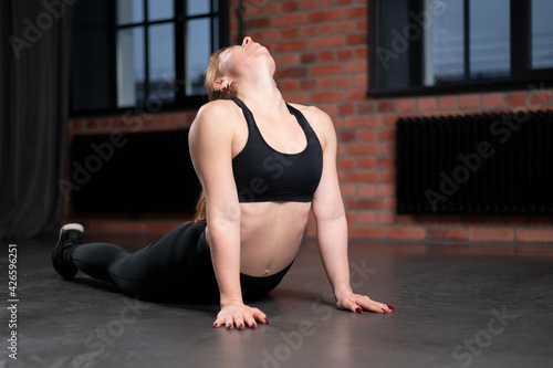 Sporty healthy young woman wear sportswear do stretching yoga exercise at home on floor. Flexible fit girl doing fitness workout sport training bending in apartment living room