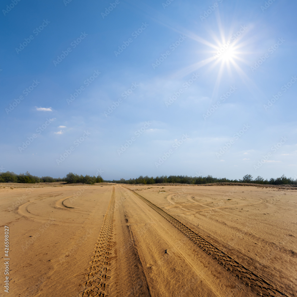 road through the sandy desert under a sparkle sun