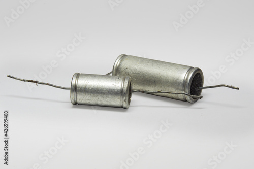 metal-paper capacitors with black flat ends. pair of vintage electronic parts of circuit of tube sound-amplifying equipment. with clipping path photo