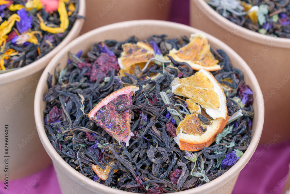 Tea with fruit and flower additives. Dry tea in a paper cup. Tea with fruit and flower additives. Dry tea in a paper cup.