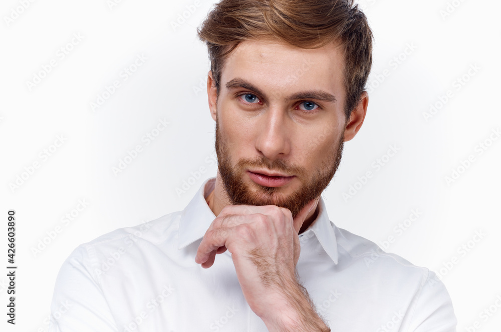 portrait of a confident man in a white shirt on a light background and a thick beard blond model