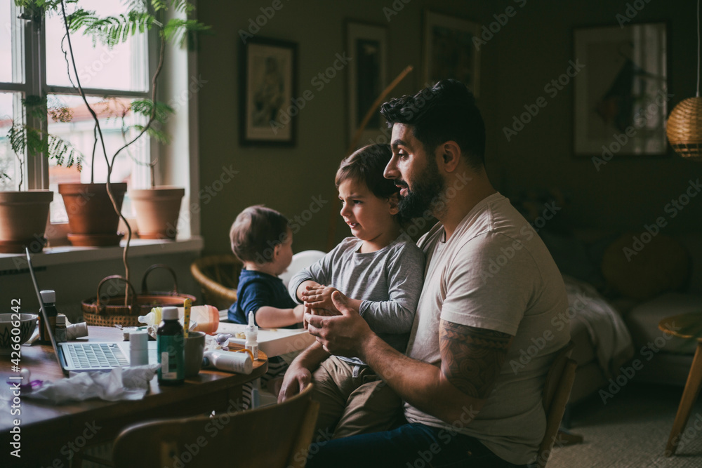 Father with children taking online advice on video with female doctor at home during pandemic Father with children taking online advice on video with female doctor at home during pandemic