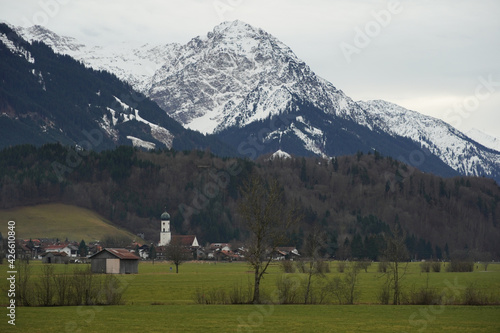 Winteruntypisches Bergpanorama in den Allg  uer Alpen mit gr  nen Talflanken und Schnee nur auf den Gipfeln