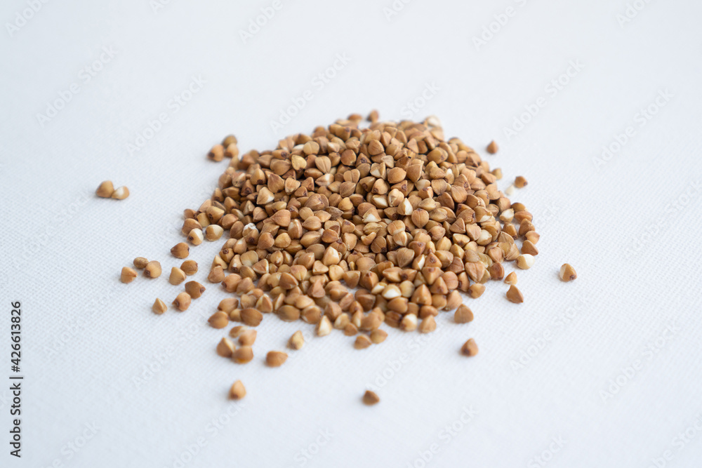 Pile of buckwheat on white background. Side view. A bunch of buckwheat close up. Isolated Pile of buckwheat on white background. Side view. A bunch of buckwheat close up. Isolated