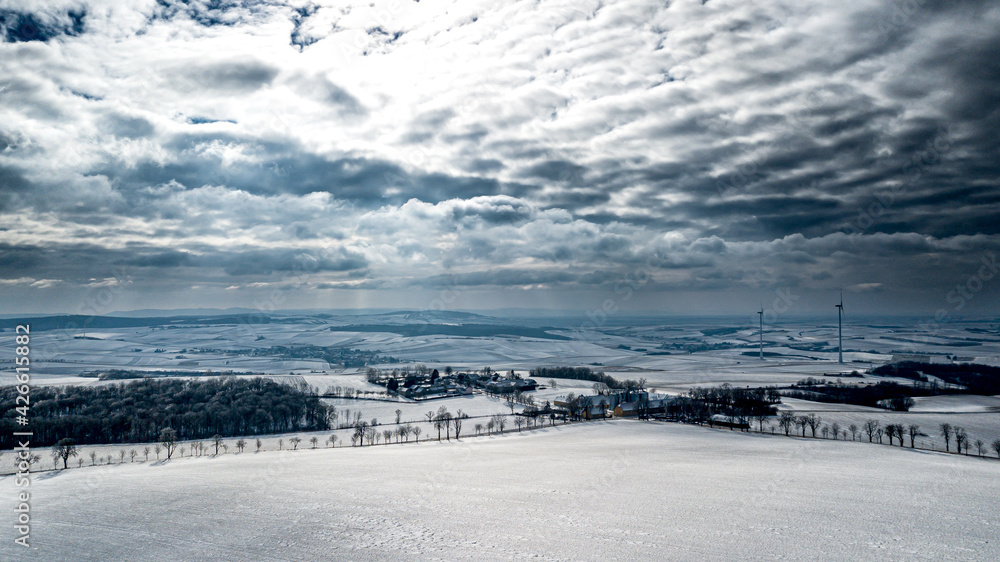 Snowy Winter Landscape With Remote Settlements And Wind Turbines In Austria
