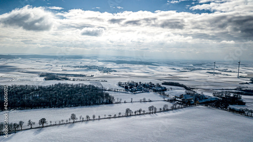 Snowy Winter Landscape With Remote Settlements And Wind Turbines In Austria