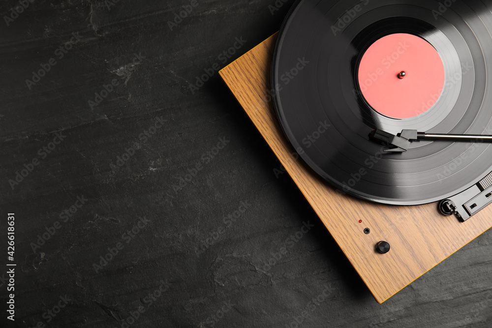 Turntable with vinyl record on black background, top view. Space for text - obrazy, fototapety, plakaty 