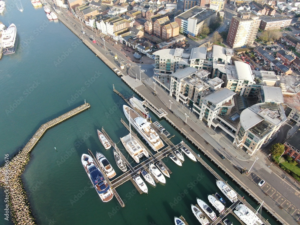 aerial view of small marina with superyachts and smaller leisure vessels moored