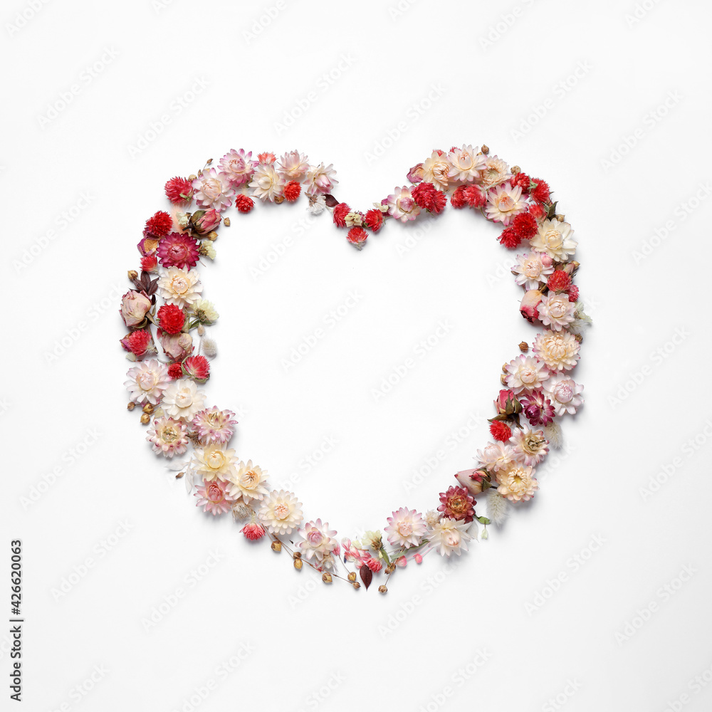 Beautiful heart shaped floral composition on light background, flat lay