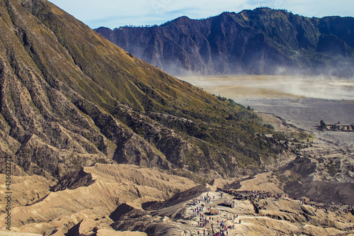 View from the top of Mount Bromo on the feet of the dormant volcano Batok,stairs leading to the crater of Bromo volcano and people ascending on its top, Bromo Tengger Semeru Park