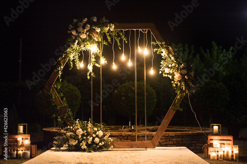 Wedding ceremony with arch in rustic style with fresh flowers and macrame