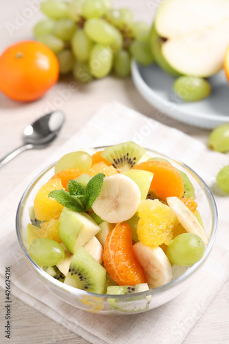 Delicious fresh fruit salad in bowl on table