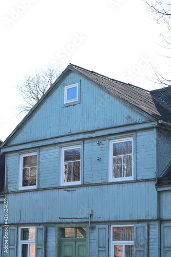 old blue wooden house with white windows