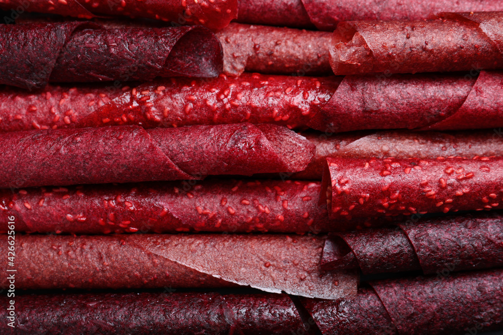 Delicious fruit leather rolls as background, top view Delicious fruit leather rolls as background, top view