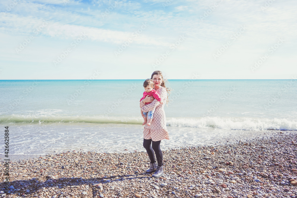 Happy family moment of a young mom enjoying a day on the beach with her baby Happy family moment of a young mom enjoying a day on the beach with her baby