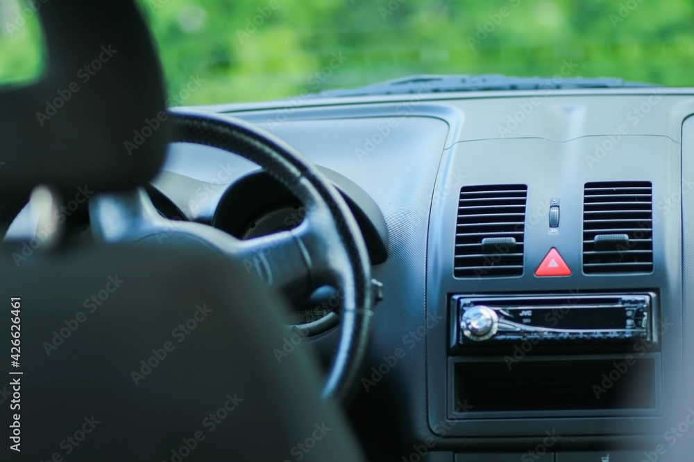 
small car interior with leather steering wheel and radio