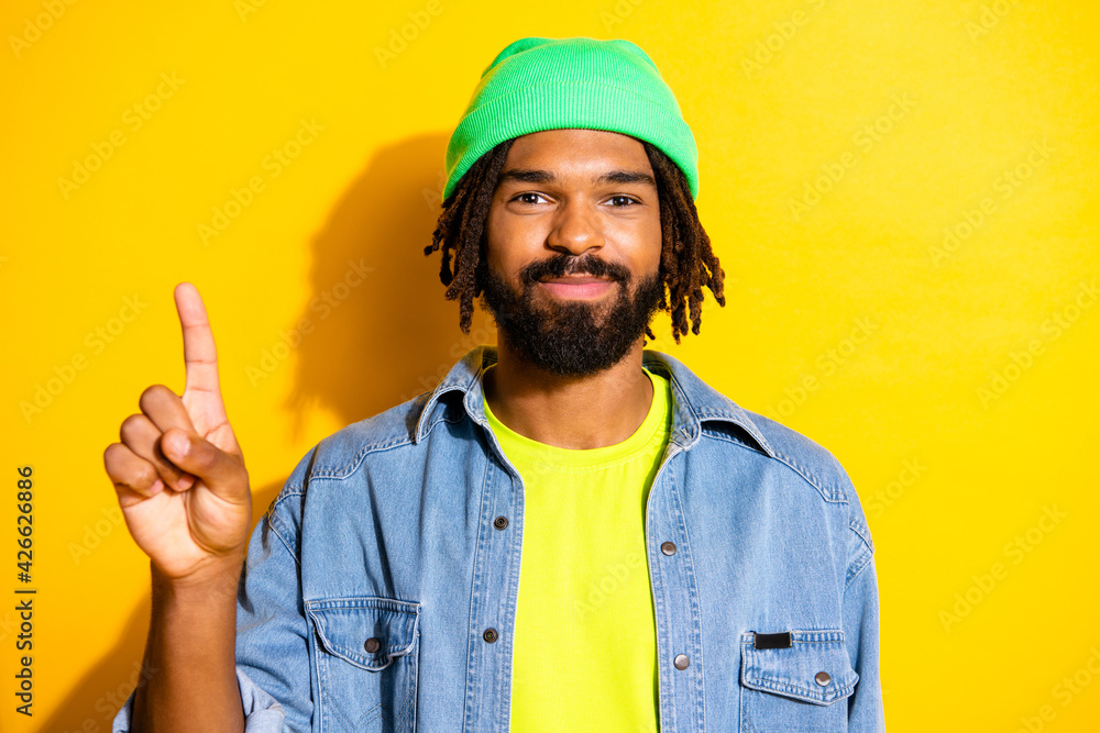 Photo of young handsome happy positive smiling man point finger copyspace advertisement isolated on yellow color background