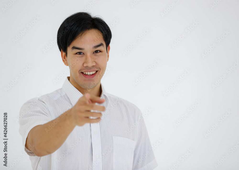 Portrait of Asian young and handsome businessman in casual shirt and slack trousers posing in advertising gesture pointing finger to camera isolated on white background.