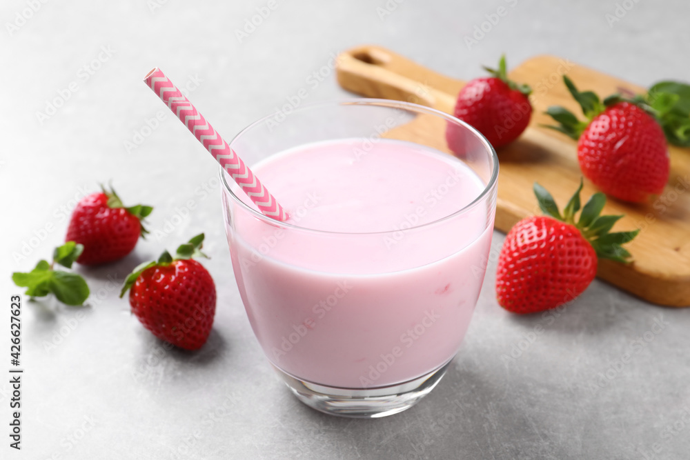 Delicious strawberry drink on light grey table Delicious strawberry drink on light grey table