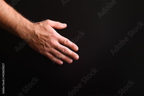 man's hand on a black background. close-up. copy space