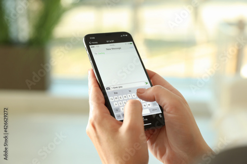 Foto Woman writing message with text I Love You on smartphone against blurred backgro
