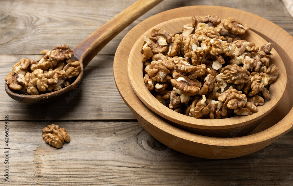 peeled walnuts in a wooden plate on the table peeled walnuts in a wooden plate on the table