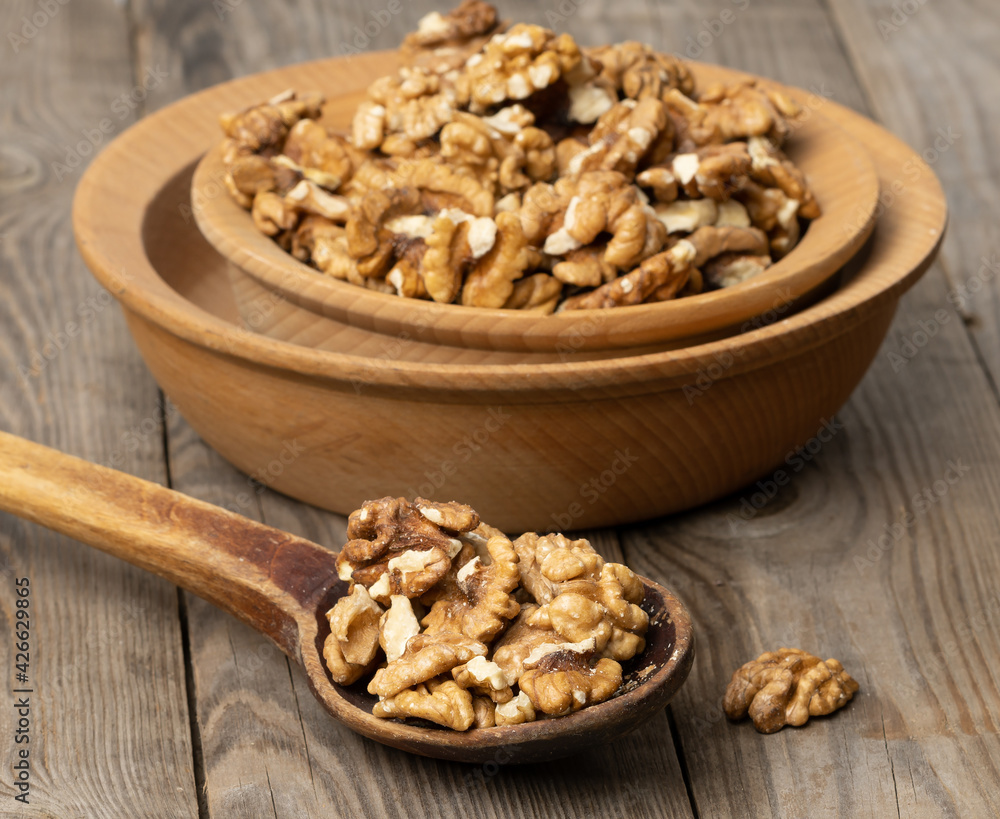 peeled walnuts in a wooden plate on the table peeled walnuts in a wooden plate on the table