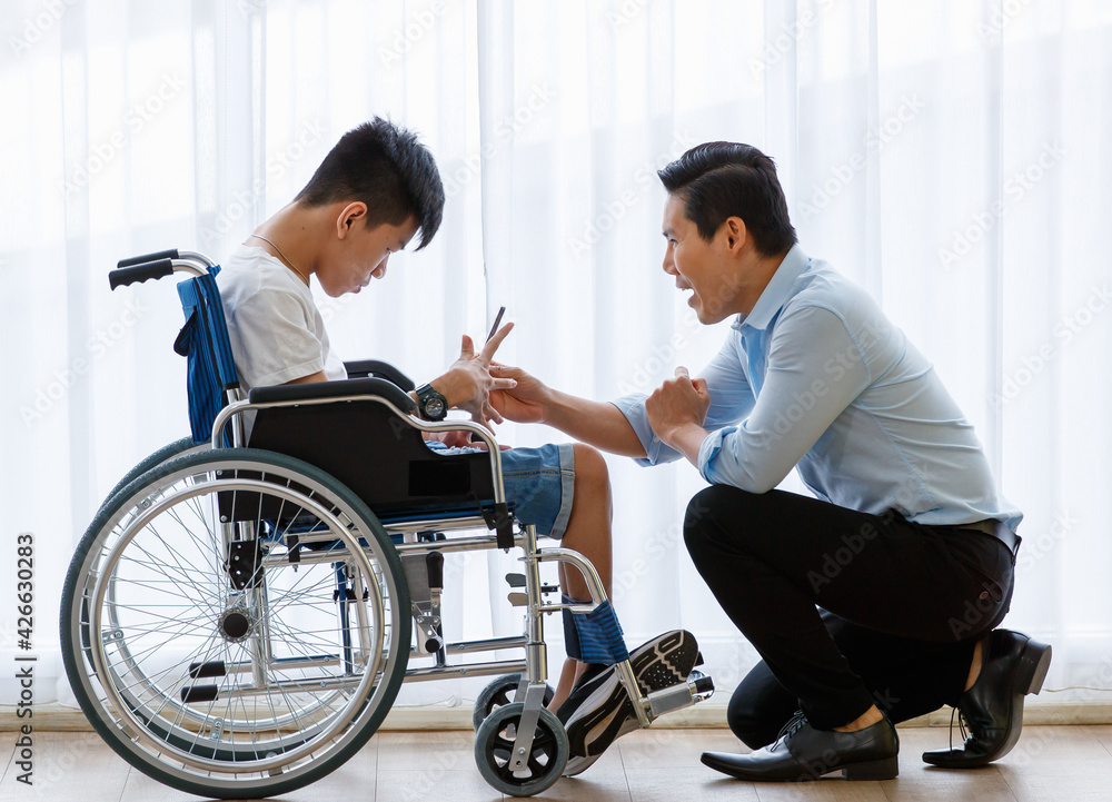 Asian doctor talking, support, and encouragement to a young disabled boy in a wheelchair Asian doctor talking, support, and encouragement to a young disabled boy in a wheelchair