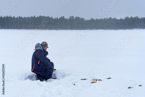 fisherman catch fish in winter in heavy snowfall. soft focus