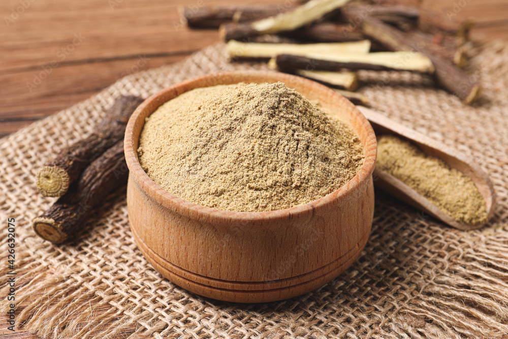 Dried sticks of liquorice root and powder on wooden table, closeup Dried sticks of liquorice root and powder on wooden table, closeup