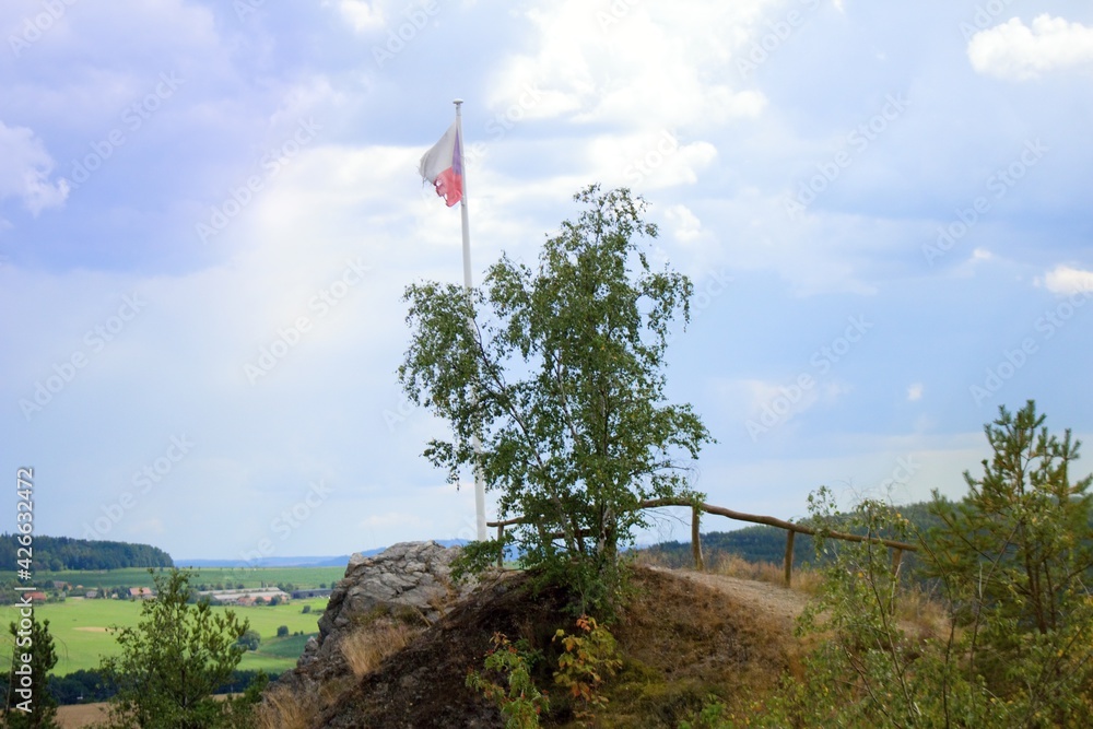 The torn Czech flag flutters in the wind on Křemenáč in Plaská pahorkatina near Břasy.