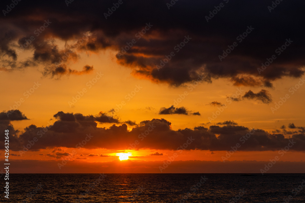Dramatic sunset over ocean. Sky with clouds.