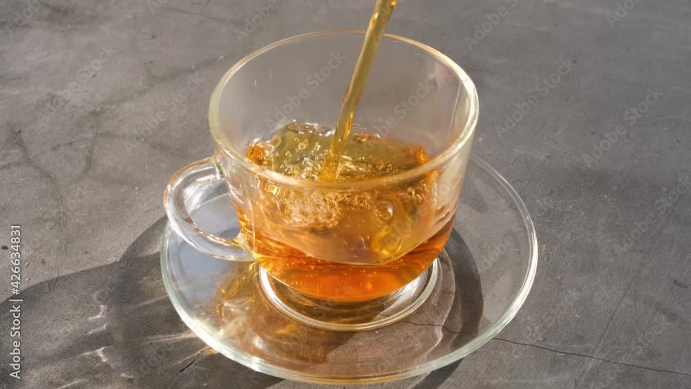 Fresh aromatic herbal tea is poured into a transparent cup. The concept of hot warming vitamin healthy drinks. Fresh aromatic herbal tea is poured into a transparent cup. The concept of hot warming vitamin healthy drinks.