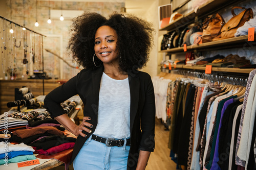 Photography Professional portrait of a young beautiful owner of dress shop at entrance of co
