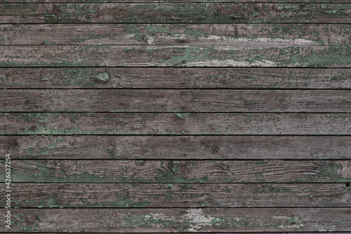 old grey plank wall background with peeled off green paint