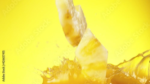 Super slow motion of pineapple slices falling into juice. Filmed on high speed cinema camera, 1000 fps. photo