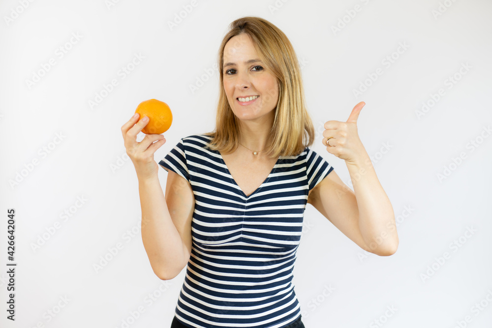 Happy woman holding orange fruit in hand. Healthy life, diet and nutrition concept. Happy woman holding orange fruit in hand. Healthy life, diet and nutrition concept.