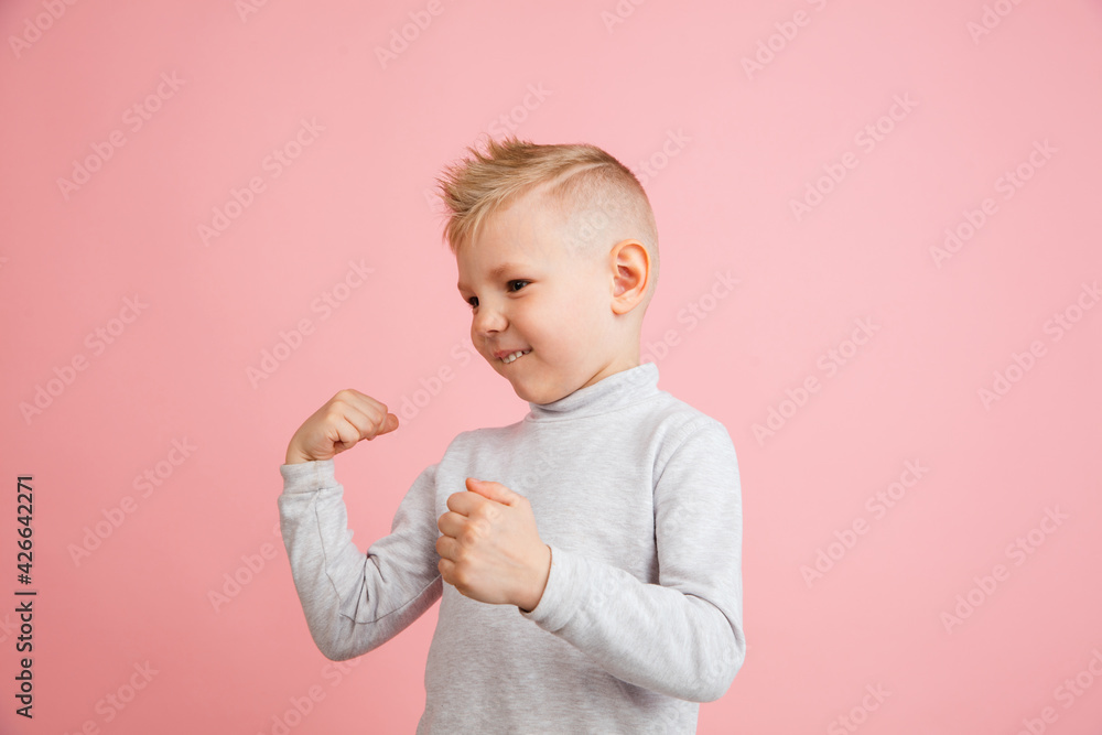 Happy boy isolated on pink studio background. Looks happy, cheerful, sincere. Copyspace. Childhood, education, emotions concept Happy boy isolated on pink studio background. Looks happy, cheerful, sincere. Copyspace. Childhood, education, emotions concept