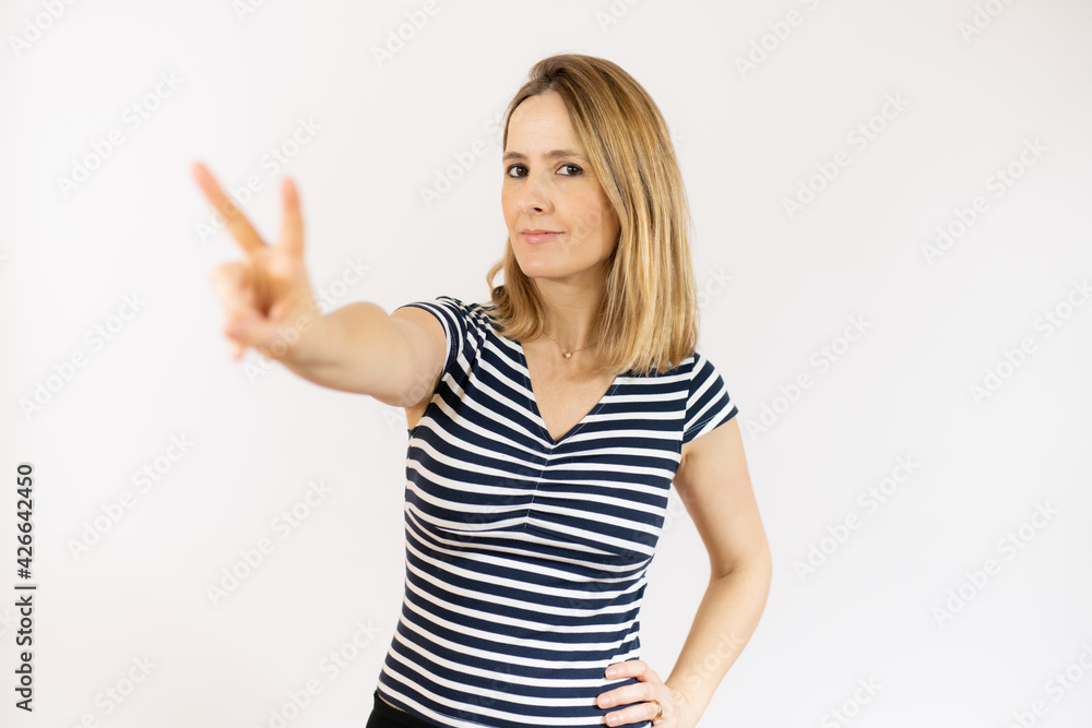 Blonde woman over isolated background smiling and showing victory sign Blonde woman over isolated background smiling and showing victory sign
