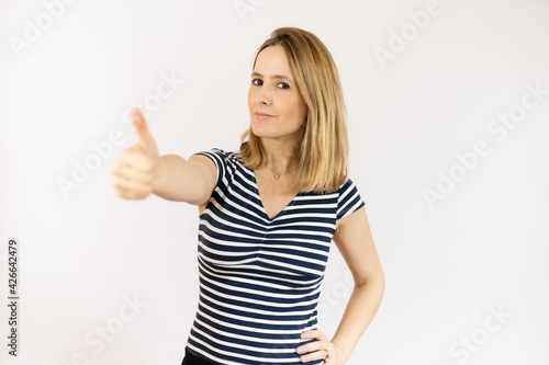 Smiling pretty young woman showing thumb up isolated over white background © Danko