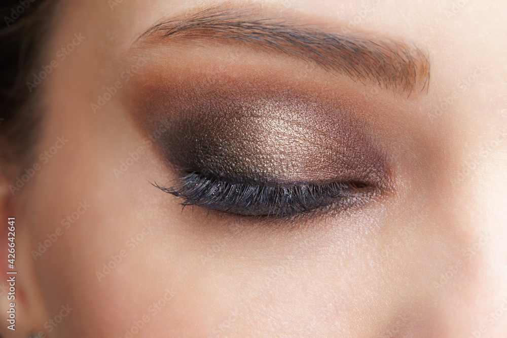Obraz premium Closeup macro shot of closed human female eye. Girl with perfect skin and pink eyes shadows
