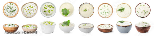 Bowls of tasty sour cream with herbs on white background photo