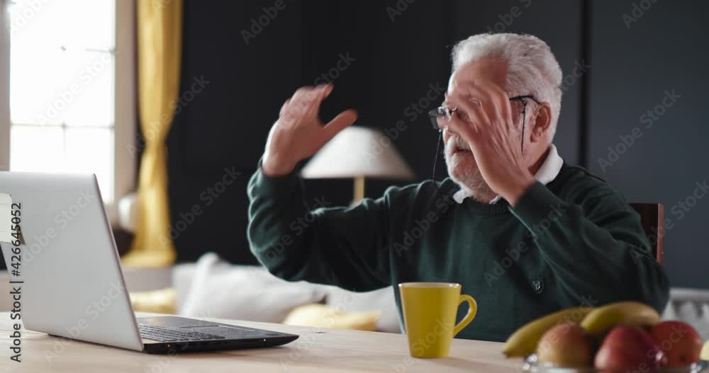 Old man is annoyed by the bad news. Concept of annoying and closing the laptop. Old man is annoyed by the bad news. Concept of annoying and closing the laptop.